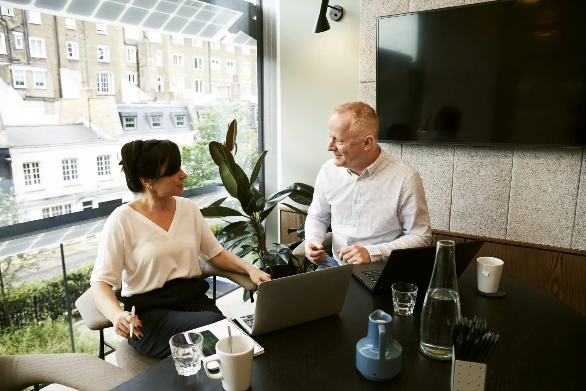 Two professionals discussing documents at a table
